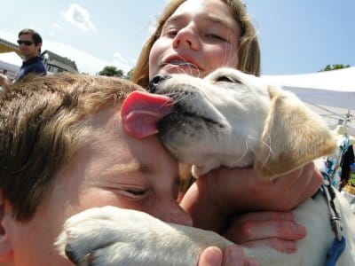 THE DOG DAYS OF SUMMER? Friends to the end, a boy and dog take a break to play kissy face after the Machias Wild Blueberry Festival's blueberry pie eating contest. (Chessie Crowe photo)