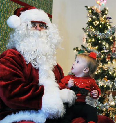 WHAT TO MY WONDERING EYES SHOULD APPEAR... Eleven-month-old Briella Mitchell looks up in wonder at Santa Claus during his visit that was hosted by the Eastport Youth Association on Sunday, D