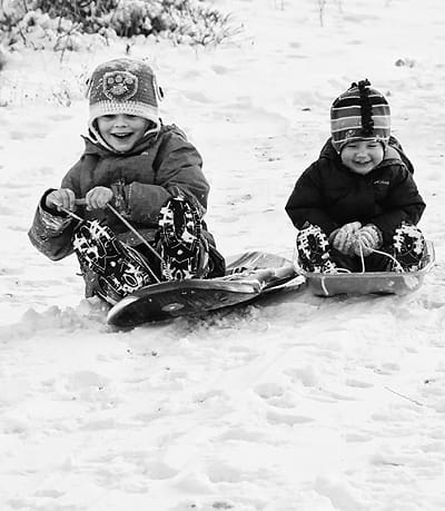 READY OR NOT, HERE WE COME! Enjoying the wintry weather by sliding down a hill in Eastport are Keene Cooke, 6, and his sister Loa, 2. (Edward French photo)