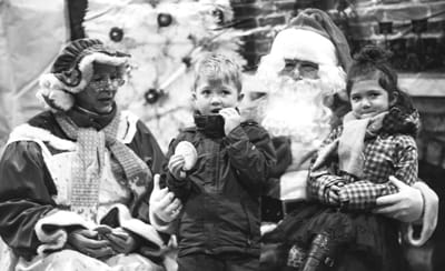FOLLOWING THE LIONESS CHRISTMAS PARADE in Calais on December 2, Eve and Silas Socobasin (above) happily sit with Santa and Mrs. Claus to share their Christmas wishes. Many children stopped b