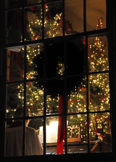 SHINING INTO THE DARKNESS are lights adorning one of the large Christmas trees in the Dennysville-Edmunds Congregational Church on December 23, as organist Robb Cook plays during the Festiva