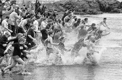 RUSHING into the water are participants in the annual Polar Dip at Pleasant Point. (Don Dunbar photo)
