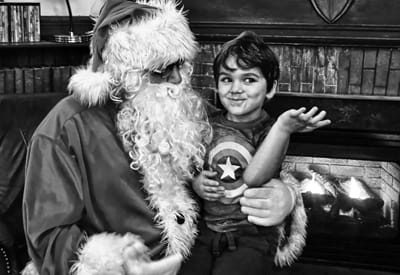 TELLING SANTA what he wants for Christmas during the community Christmas party at the Peavey Memorial Library in Eastport on December 8 is Robin Leavitt. (Don Dunbar photo)