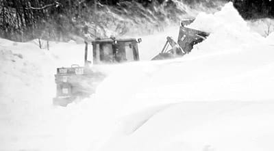 CLEARING SNOW DRIFTS in high winds on the Deep Cove Road in Eastport after the St. Patrick's Day snowstorm is the city's payloader, operated by Cody Preston. (Edward French photo)