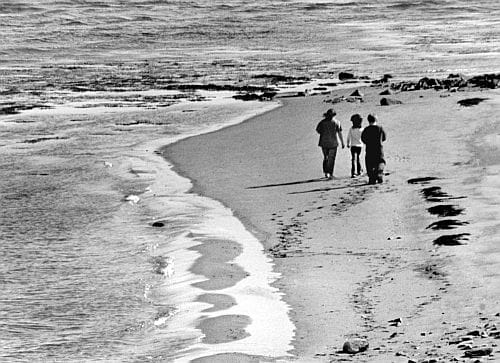 LEAVING FOOTPRINTS IN THE SAND, on the edge between land and sea, a trio of youngsters walks along the sand beach in Eastport's South End, enjoying the spring weather. (Edward French photo) 