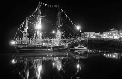 LIT UP during the Eastport Area Chamber of Commerce social on Thursday, September 6, is the HMS Bounty, which was docked at the Eastport fish pier through the Pirate Festival. (Don Dunbar ph