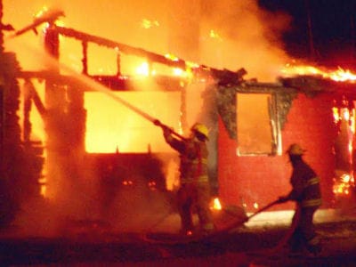 FIREFIGHTERS spray water on an unoccupied house on the Lake Road in Perry that burned on April 26. (Tom McLaughlin photo)