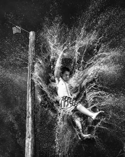 Below, a contestant makes a big splash after missing the flag in the greasy pole contest .during the Eastport Fourth of July celebration. Don Dunbar photo