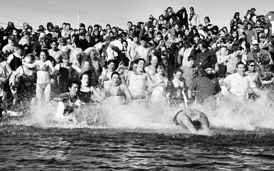 IT"S A MAD RUSH to enter the water for Polar Bear Dip participants on Friday, February 4, at Pleasant Point. The event, sponsored by the Washington County Community College Student Senate, r