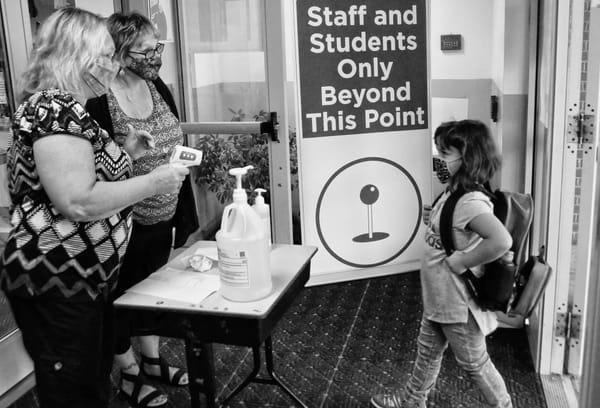 PUTTING ON A BRAVE FACE behind her mask, Eastport Elementary School student Keyanah Chasse is welcomed on the first day of the reopening of school since the pandemic hit last March by educat