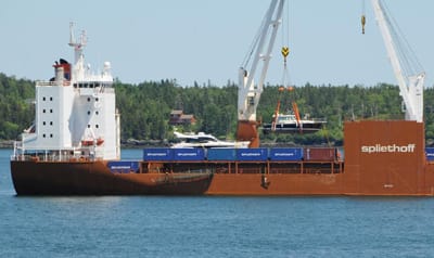 BIG AND LITTLE SHIPS. The Stadiongracht anchored off Eastport on June 17 and 18 to unload a 42-foot yacht that was shipped from Antwerp, Belgium. The yacht, which had been built in Maine bef