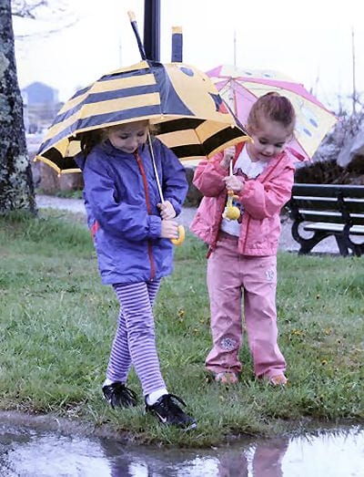 ON A MISTY, MOISTY MORNING, Tiernan and Molleigh Cox of Red Beach keep dry under their colorful umbrellas, as they watch out for puddles in downtown Eastport. (Edward French photo) Subscribe