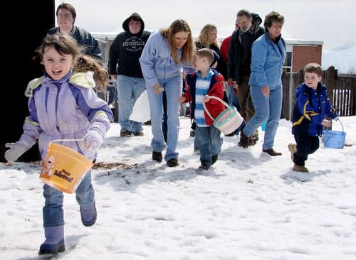 LEADING THE DASH is Chloe Alley, clutching her Halloween bucket, while Joey Moores and Kaden Estabrooks take a slower approach to hunting eggs in Lubec's Easter Egg Scramble -- as the ground