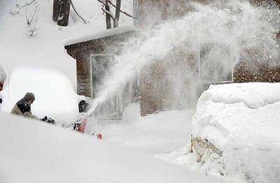 THE YEAR OF THE NEVER-ENDING SNOW. Wayne Tripp clears the snow away at his Sullivan St. home in Eastport, as another 10.6 inches fell on February 25. The Eastport/Lubec area has now received