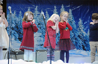 VISIONS OF SUGAR-PLUMS DANCED IN THEIR HEADS... Singing “The Lights on the Tree” during the winter holiday concert on December 17 at the Eastport Elementary School are K4 and K5 students Che