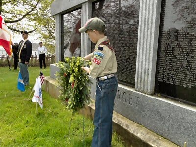 PLACING A WREATH at the Honor Roll Monument in Lubec in remembrance of U.S. Army veterans is Robert Swallow of Cub Scout Pack #150, during the town's Memorial Day commemoration on May 30. (C