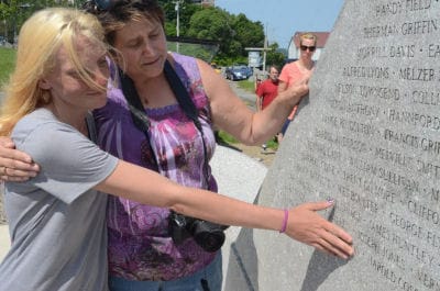 COMFORTING Jessica Jones is Lost Fishermen’s Memorial Association President Shelly Tinker after the unveiling of the newly installed memorial in Lubec. Jones’ brother Joseph was the captain 