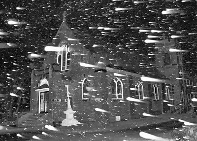 SNOW FLIES PAST in the stormy night sky, as St. Ann's Catholic Church at Pleasant Point awaits the beginning of the Christmas season. (Edward French photo)