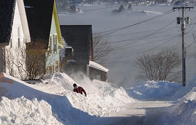 IN THE DEPTHS OF WINTER, snow and sea smoke dwarf a shoveller at the bottom of Clark St. in Eastport. (Edward French photo) Subscribe to Quoddy Tides Rates:$31.65 a year in Washington County