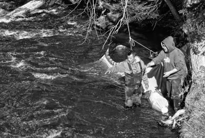 SECURING THEIR ELVER FYKE NET in the Little River in Perry are Dwayne Tomah and his son D.J. Sockabasin. Although cold weather has caused a slow start to the elver season, prices are at a re