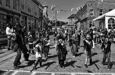 EN GARDE FOR THE END OF SUMMER! After being trained in sword fighting, these children march through town to battle with pirates at Bank Square during the Eastport Pirate Festival. (Don Dunba